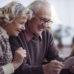 Elderly husband and wife networking at home
